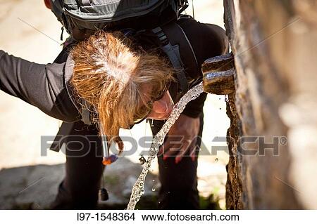 Woman drinking from a water fountain on the Camino de Santiago View Large Photo Image Picture - Woman drinking from a water fountain on the Camino de Santiago. Fotosearch