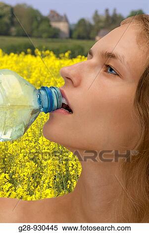 Woman drinking water and rape field View Large Photo Image Stock Photography - Woman drinking water and rape field. Fotosearch