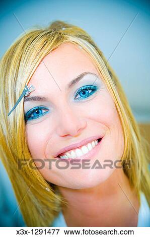 Stock Photo - Woman during a make up and hair styling session. Fotosearch