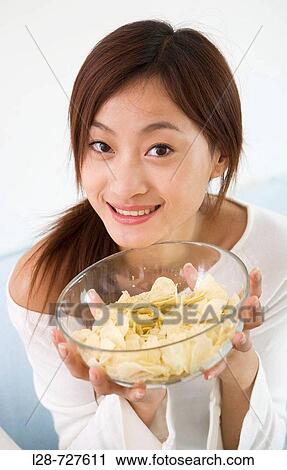 Woman eating chips on sofa View Large Photo Image Stock Image - Woman eating chips on sofa. Fotosearch