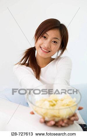 Woman eating chips on sofa View Large Photo Image Stock Image - Woman eating chips on sofa. Fotosearch