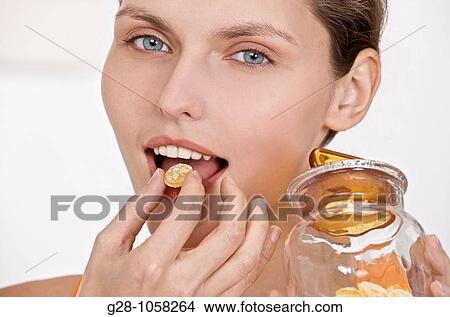 Woman eating honey sweets for sore throat View Large Photo Image Picture - Woman eating honey sweets for sore throat. Fotosearch