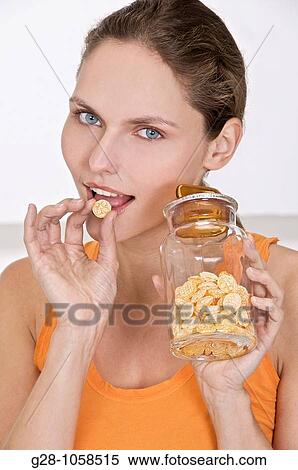 Stock Photography - Woman eating honey sweets for sore throat. Fotosearch