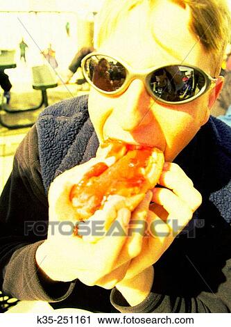 Woman eating hot dog View Large Photo Image Stock Image - Woman eating hot dog. Fotosearch