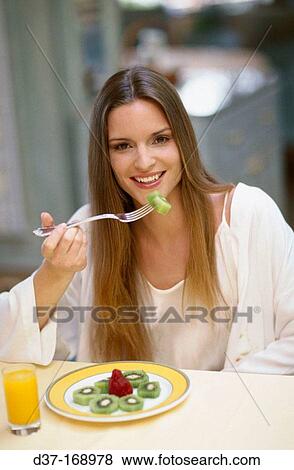 Woman eating kiwi View Large Photo Image Stock Photo - Woman eating kiwi. Fotosearch