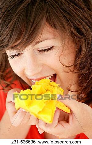 Woman eating mango View Large Photo Image Stock Photograph - Woman eating mango. Fotosearch