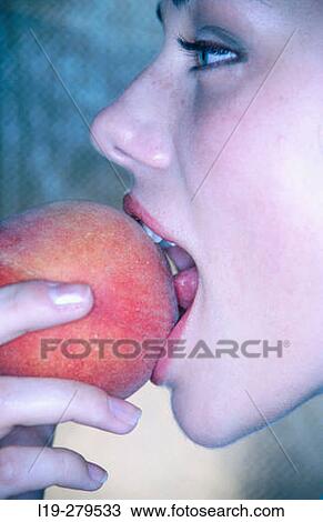 Stock Image - woman eating peach. Fotosearch
