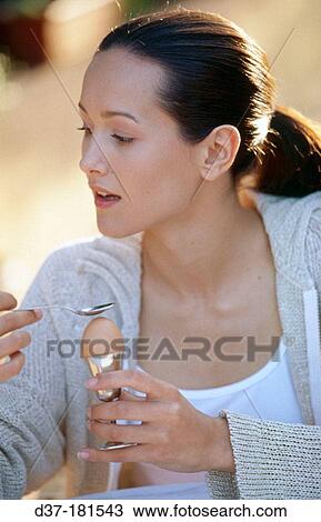 Woman eating soft-boiled egg View Large Photo Image Stock Image - Woman eating soft-boiled egg. Fotosearch