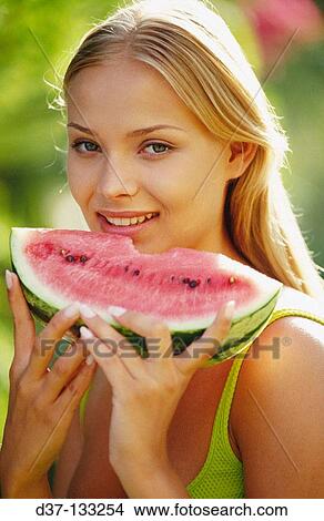 Picture - Woman eating watermelon. Fotosearch
