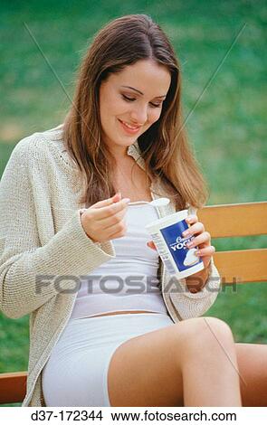 Woman eating yoghurt View Large Photo Image Picture - Woman eating yoghurt. Fotosearch