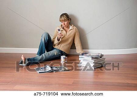 Woman empty room, using cell phone View Large Photo Image Picture - Woman empty room, using cell phone. Fotosearch