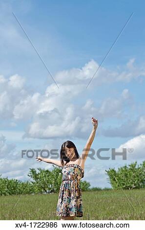 Stock Photograph - Woman enjoy at ruralscape with her Arms Raised. Fotosearch