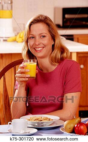 Stock Image - woman enjoying a healthy breakfast. Fotosearch