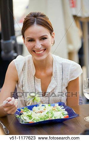 Woman enjoying a salad outdoor in a restaurant View Large Photo Image Stock Image - Woman enjoying a salad outdoor in a restaurant. Fotosearch