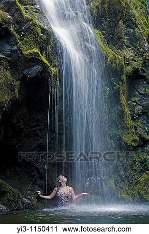 Woman enjoys a waterfall on the road to Hana, Maui, Hawaii, USA View Large Photo Image Stock Image - Woman enjoys a waterfall on the road to Hana, Maui, Hawaii, USA. Fotosearch