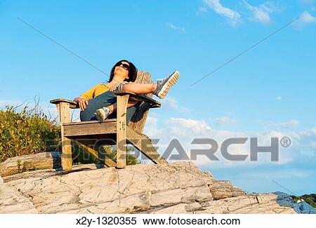 Woman enjoys the coastal view while speaking on a mobile phone View Large Photo Image Stock Photography - Woman enjoys the coastal view while speaking on a mobile phone. Fotosearch
