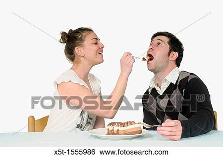 Woman feeds cream cake to a man View Large Photo Image Stock Photograph - Woman feeds cream cake to a man. Fotosearch