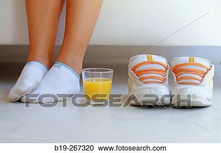Woman feet and orange juice and sports shoes on the floor View Large Photo Image Stock Image - Woman feet and orange juice and sports shoes on the floor. Fotosearch