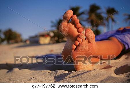 Stock Image - Woman feet on the beach. Fotosearch