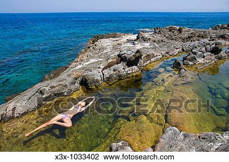 Woman floating in colorful water pool by the sea Pantelleria Island, Sicily, Italy View Large Photo Image Stock Image - Woman floating in colorful water pool by the sea Pantelleria Island, Sicily, Italy. Fotosearch