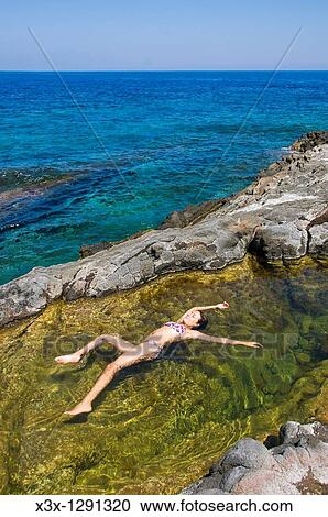 Woman floating in colorful water pool by the sea Pantelleria Island, Sicily, Italy View Large Photo Image Stock Image - Woman floating in colorful water pool by the sea Pantelleria Island, Sicily, Italy. Fotosearch