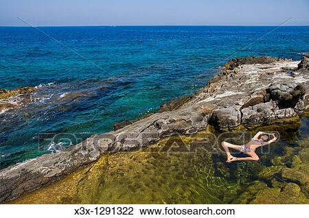 Woman floating in colorful water pool by the sea Pantelleria Island, Sicily, Italy View Large Photo Image Stock Image - Woman floating in colorful water pool by the sea Pantelleria Island, Sicily, Italy. Fotosearch