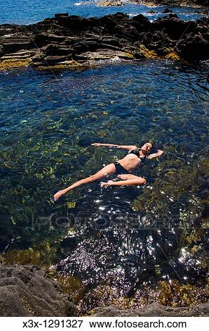 Woman floating in the Mediterranean water Island of Pantelleria, Sicily, Italy View Large Photo Image Stock Photo - Woman floating in the Mediterranean water Island of Pantelleria, Sicily, Italy. Fotosearch