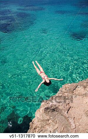 Woman floating in water at a beach in Portinax, Ibiza, Balearic Islands, Spain View Large Photo Image Stock Image - Woman floating in water at a beach in Portinax, Ibiza, Balearic Islands, Spain. Fotosearch
