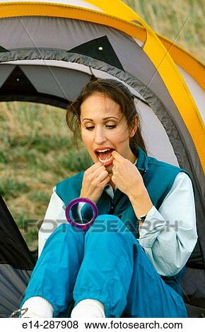 Stock Photo - Woman flossing teeth in camping. Chugach State Park. Southcentral Alaska. Fotosearch
