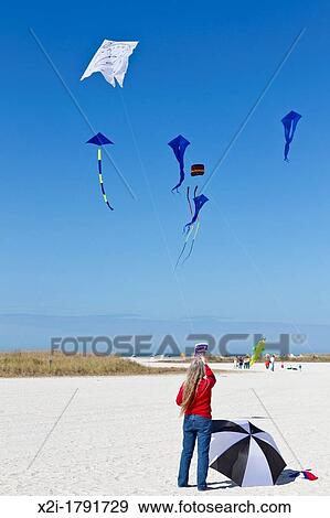 Woman flying kite with a Dali style clock face on St Pete Beach at the Treasure Island Kite Festival in Treasure Island, Florida View Large Photo Image Stock Photo - Woman flying kite with a Dali style clock face on St Pete Beach at the Treasure Island Kite Festival in Treasure Island, Florida. Fotosearch
