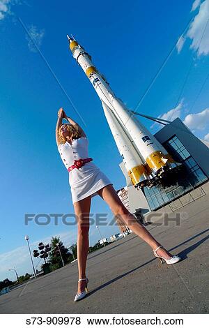 Stock Photo - Woman front the Russian space transport rocket. A museum piece. Samara. Russia.. Fotosearch