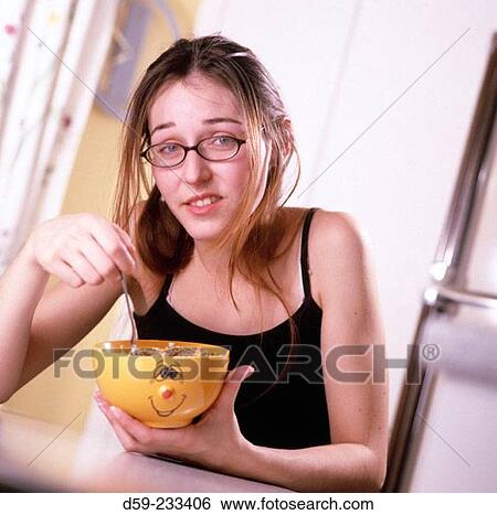 Woman frowning while having her breakfast View Large Photo Image Stock Photograph - Woman frowning while having her breakfast. Fotosearch