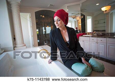 Woman getting her bath ready View Large Photo Image Stock Photo - Woman getting her bath ready. Fotosearch