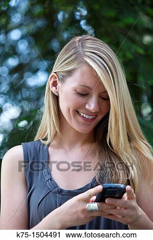 Stock Image - Woman getting or sending a text message. Fotosearch