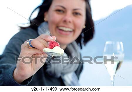 Stock Photo - Woman giving raspberry and ice cream with a spoon. Fotosearch