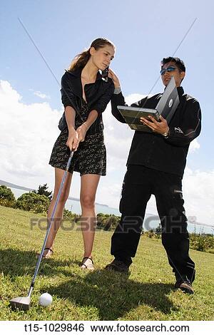 woman golfing talking on phone and looking at a laptop View Large Photo Image Stock Photograph - woman golfing talking on phone and looking at a laptop. Fotosearch