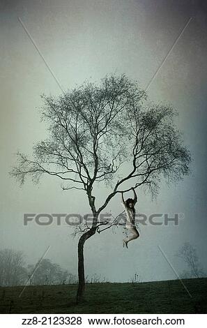 Stock Photo - Woman hanging on the tree.. Fotosearch