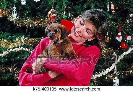 Stock Photography - Woman happy with Christmas puppy. Fotosearch