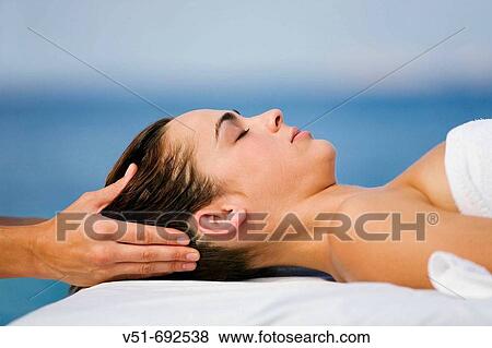 Woman having a head massage by the sea View Large Photo Image Stock Photo - Woman having a head massage by the sea. Fotosearch
