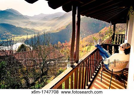 Stock Photo - Woman having a rest in a holiday cottage Campiellos Sobrescobio Redes National Park, Asturias, Spain. Fotosearch