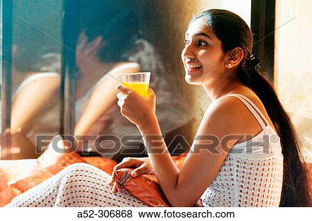 Woman having an orange juice View Large Photo Image Stock Photo - Woman having an orange juice. Fotosearch