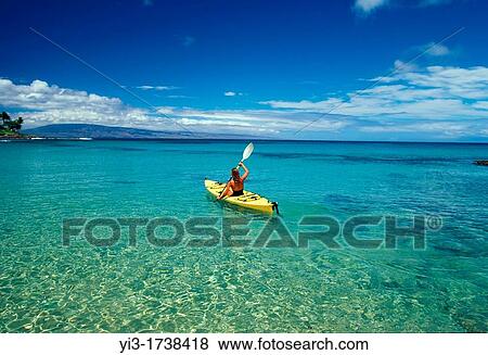 Stock Photo - Woman heads out in a kayak at Napili Bay, Maui, Hawaii. Fotosearch