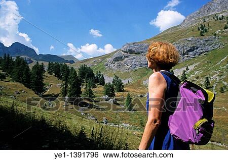 Woman hiker looking out over the mountainous landscape View Large Photo Image Stock Photograph - Woman hiker looking out over the mountainous landscape. Fotosearch