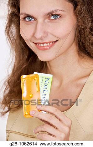 Picture - Woman holdind the morning ater contraceptive pill. Fotosearch