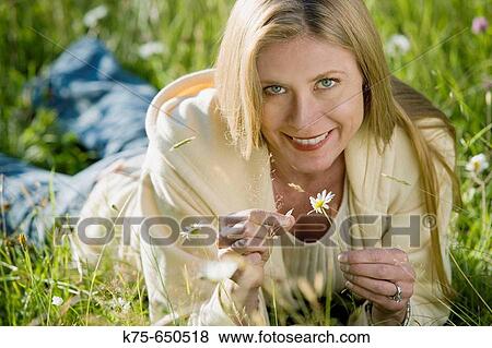 Stock Photo - woman holding a daisy. Fotosearch