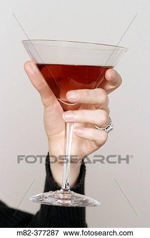 Woman holding a martini glass in her handumber 1003 View Large Photo Image Stock Photo - Woman holding a martini glass in her handumber 1003. Fotosearch