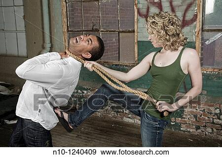 Stock Photo - Woman holding a rope around a man's neck. Fotosearch
