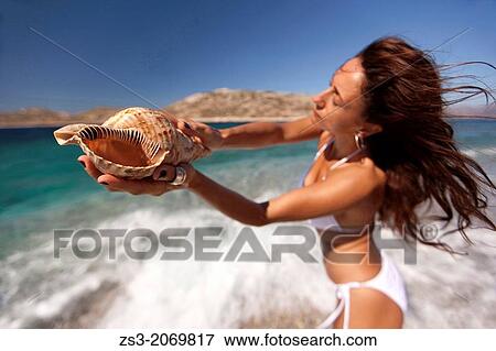 Woman holding a winkle in her hand, Naxos, Cyclades Islands, Greek Islands, Greece, Europe. View Large Photo Image Stock Photo - Woman holding a winkle in her hand, Naxos, Cyclades Islands, Greek Islands, Greece, Europe.. Fotosearch