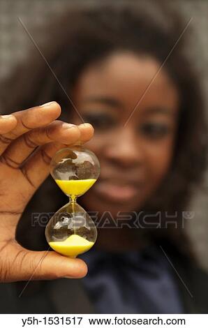 Woman holding an hourglass View Large Photo Image Stock Photo - Woman holding an hourglass. Fotosearch