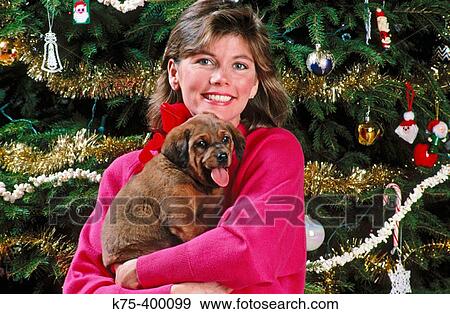 Stock Photo - Woman holding Christmas puppy. Fotosearch